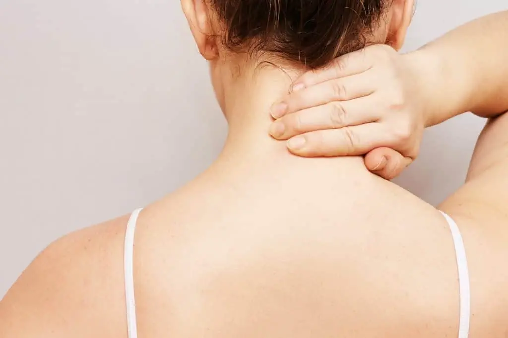 Eine Frau berührt sanft ihren Hals mit der Hand und erhält Linderung durch osteopathische Techniken, die von einem erfahrenen Osteopathen in Hamburg durchgeführt werden.