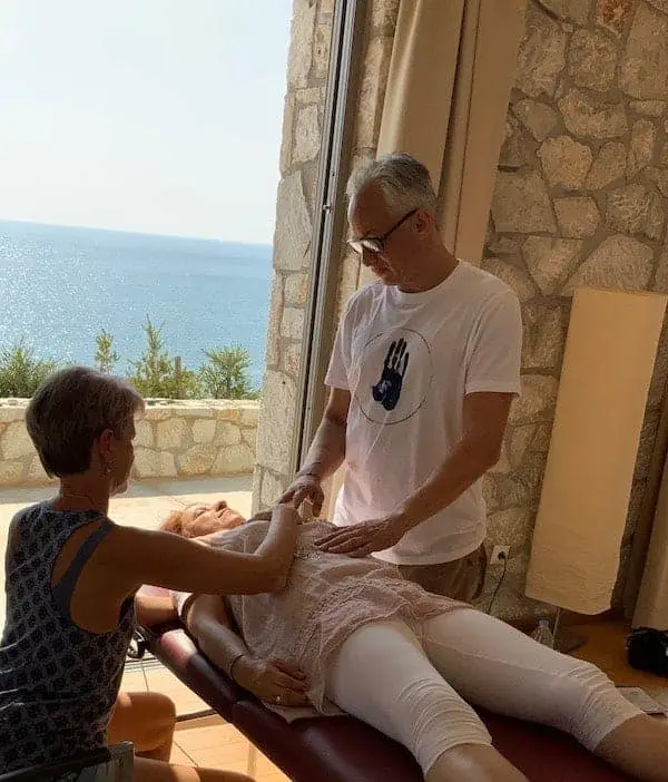 Eine Frau genießt eine Massage mit Blick auf den ruhigen Blick auf das Meer.