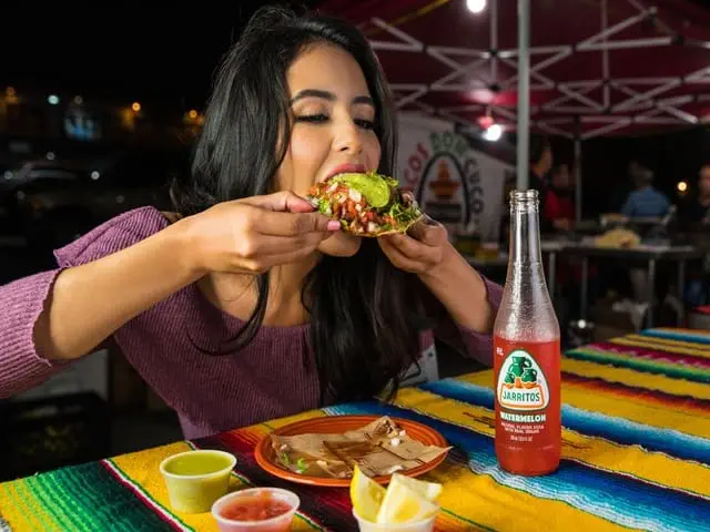 Eine Frau genießt einen Taco in einem mexikanischen Restaurant.
