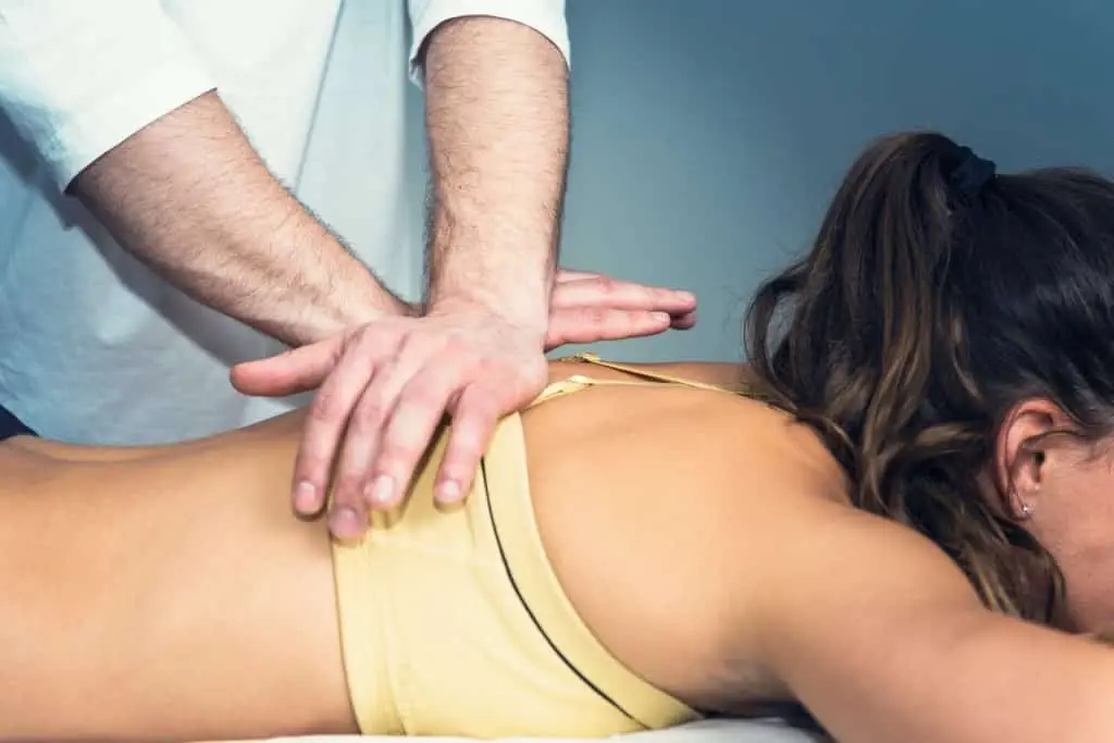 Eine Frau erhält eine entspannende Rückenmassage von einem Therapeuten.