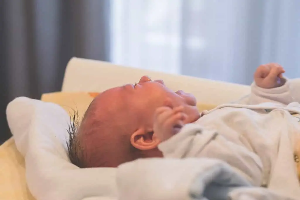 Ein Baby ruht friedlich in einem Kinderbett, während es sanfte Sportosteopathie erhält.