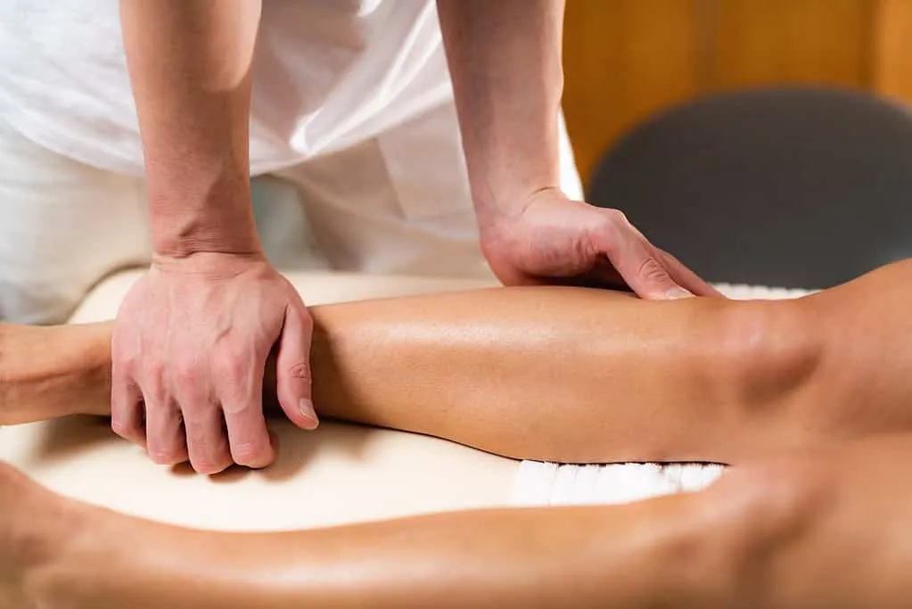 Eine Frau erhält eine Beinmassage von einem Osteopathen in Hamburg.