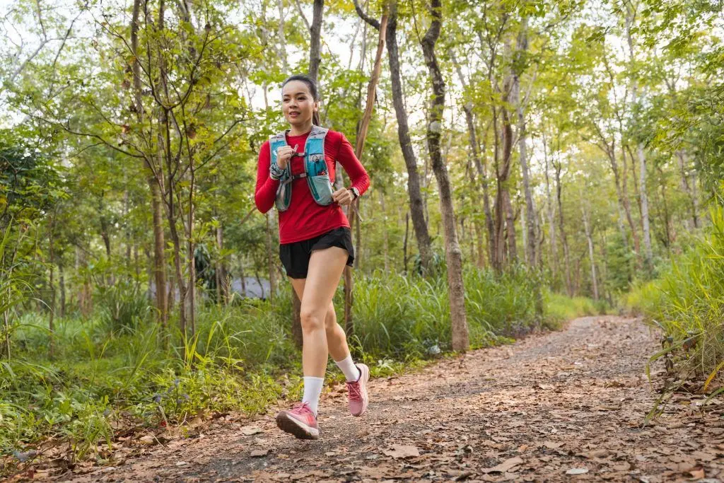 Eine Frau genießt eine erholsame Joggingrunde durch den malerischen Wald.