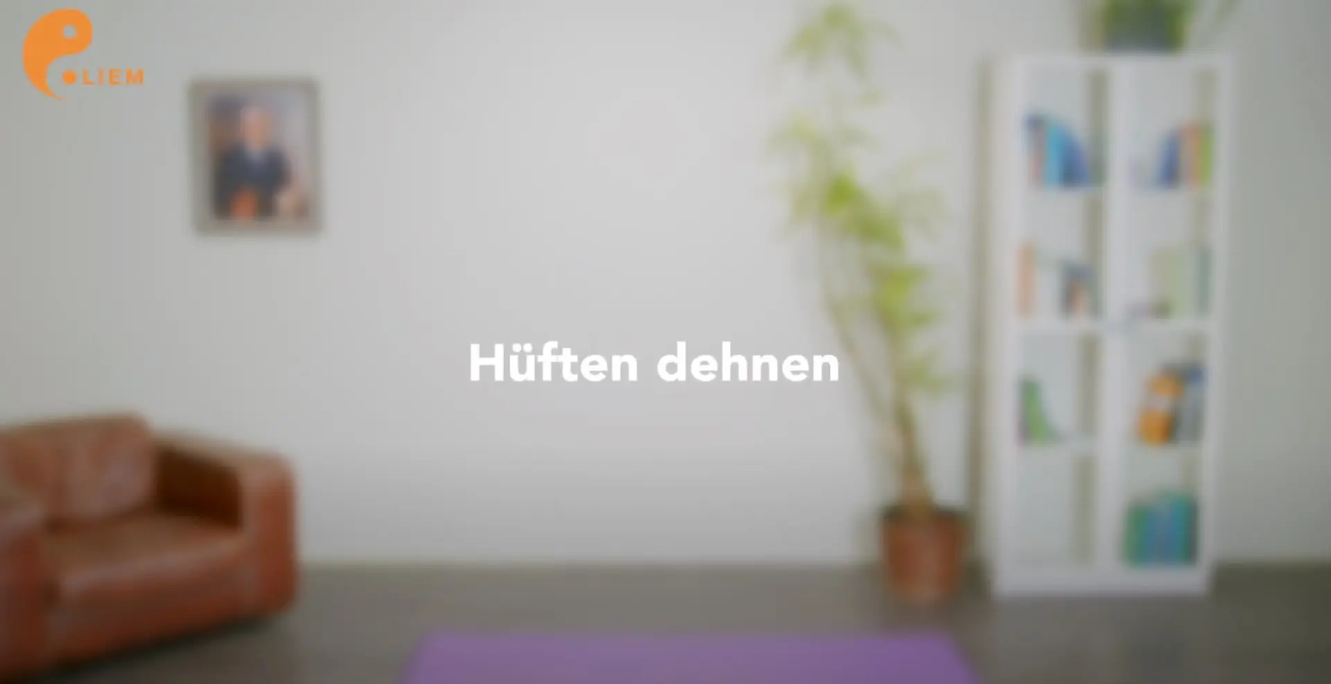 Ein Wohnzimmer mit einem braunen Ledersessel auf der linken Seite, einer großen Pflanze in einem Topf in der Mitte und einem weißen Bücherregal auf der rechten Seite. Auf dem Boden liegt eine lila Yogamatte mit dem Text in der Mitte „Hüften dehnen“ für eine effektive Hüftdehnung.